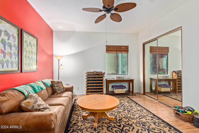 bedroom with a wall unit AC, stainless steel refrigerator, and ceiling fan