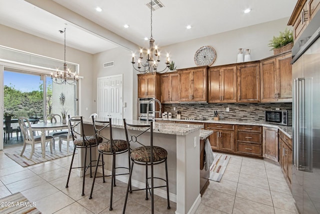 42429 N Cross Timbers Ct, Anthem, AZ 85086 - kitchen with a chandelier, tasteful backsplash, light tile patterned floors, stainless steel appliances, and recessed lighting
