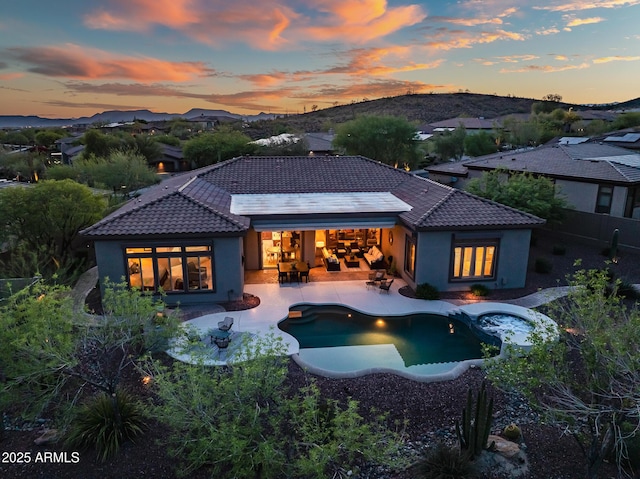 42429 N Cross Timbers Ct, Anthem, AZ 85086 - back of property at dusk featuring a tiled roof, stucco siding, a patio, and a fenced backyard