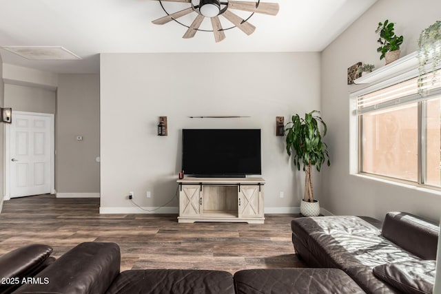 living area featuring wood finished floors, a ceiling fan, and baseboards