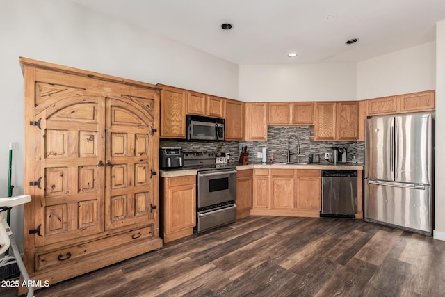 kitchen with tasteful backsplash, stainless steel appliances, light countertops, and a sink