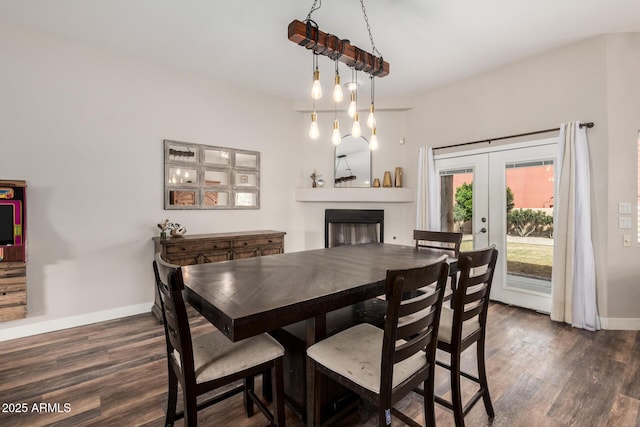 dining space featuring french doors, baseboards, wood finished floors, and a fireplace