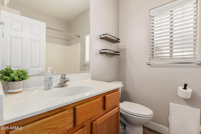 full bath featuring toilet, walk in shower, and vanity