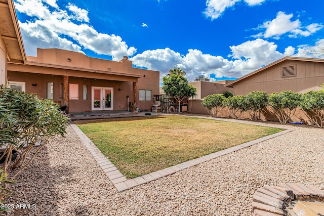 view of yard featuring a patio, french doors, and fence