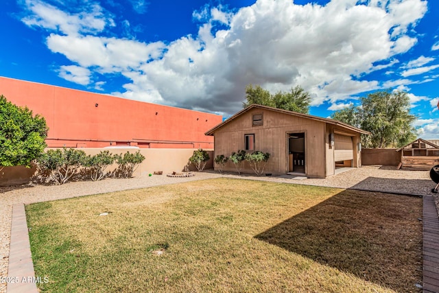 view of yard with a garage, an outdoor structure, and a fenced backyard