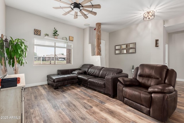 living area featuring baseboards, a ceiling fan, and wood finished floors