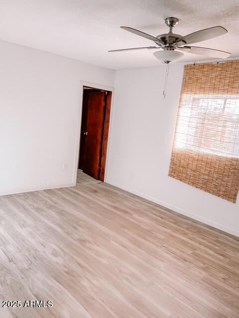 627 N H Ave, Douglas, AZ 85607 - empty room featuring light wood-style flooring, baseboards, and a ceiling fan
