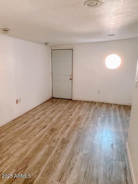627 N H Ave, Douglas, AZ 85607 - spare room with a textured ceiling, wood finished floors, and baseboards