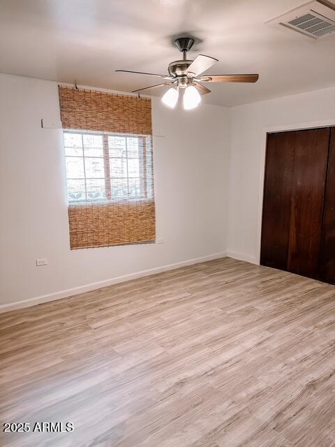627 N H Ave, Douglas, AZ 85607 - unfurnished bedroom featuring ceiling fan, light wood-style flooring, a closet, visible vents, and baseboards