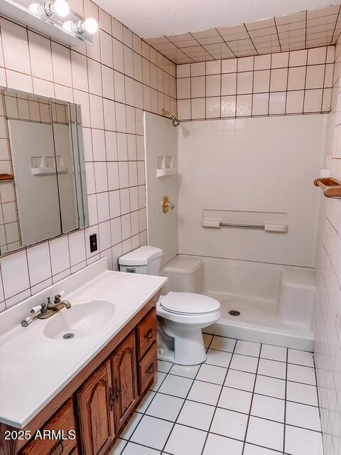 627 N H Ave, Douglas, AZ 85607 - bathroom with tile patterned floors, tile walls, a shower, and vanity