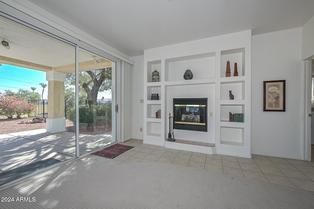 unfurnished living room with light tile patterned flooring and built in features