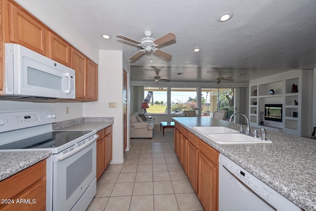 kitchen with sink, ceiling fan, a textured ceiling, light tile patterned floors, and white appliances