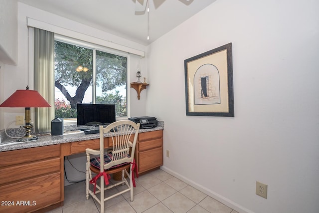 tiled office space featuring built in desk and ceiling fan