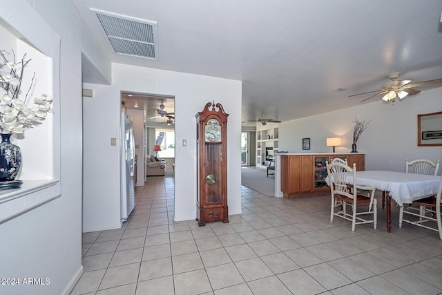 kitchen featuring ceiling fan, stainless steel refrigerator, and light tile patterned floors