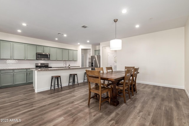 dining area with dark hardwood / wood-style floors and sink