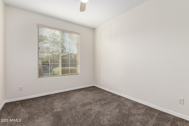 spare room featuring dark carpet and ceiling fan