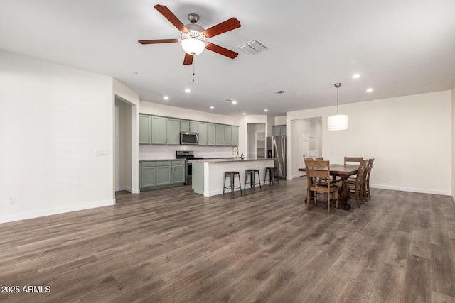 dining area with dark wood-type flooring, sink, and ceiling fan