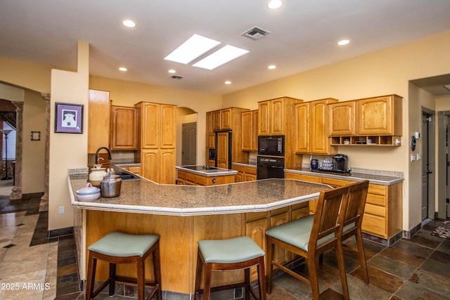 6334 E Albany St, Mesa, AZ 85205 - kitchen with black appliances, a sink, baseboards, a breakfast bar area, and recessed lighting
