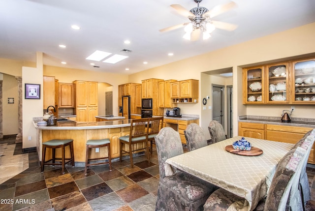 6334 E Albany St, Mesa, AZ 85205 - dining area with arched walkways, recessed lighting, a ceiling fan, and dark stone finish flooring