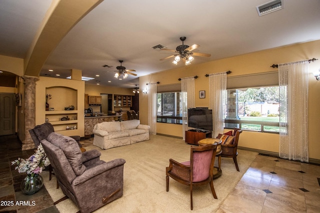 6334 E Albany St, Mesa, AZ 85205 - living room with decorative columns, arched walkways, a ceiling fan, light tile patterned floors, and baseboards