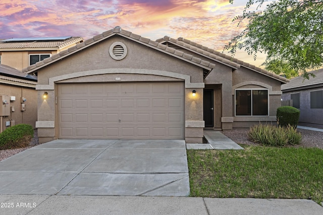 view of front of property featuring driveway, an attached garage, and stucco siding