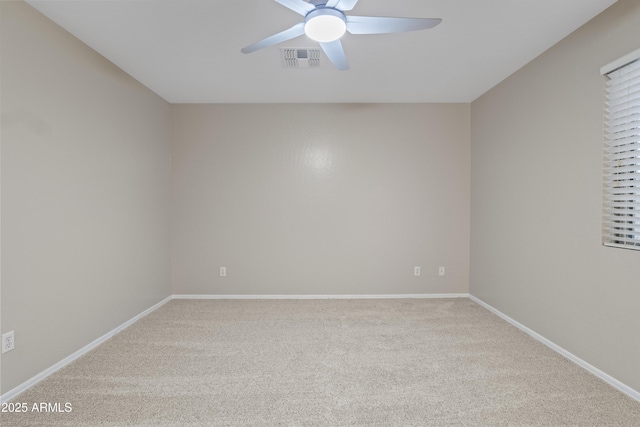 empty room featuring light colored carpet, visible vents, a ceiling fan, and baseboards