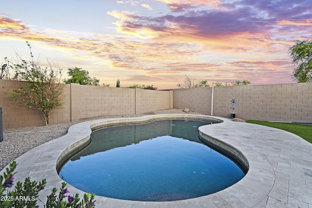 pool at dusk featuring a fenced in pool, a fenced backyard, and a patio area