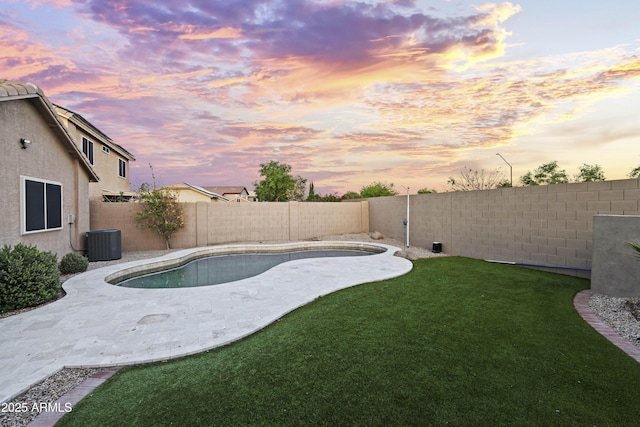 pool at dusk with a fenced in pool, a yard, central AC, and a fenced backyard