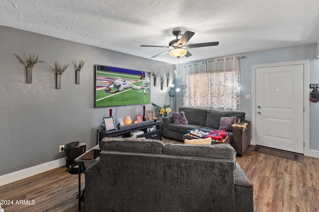 living room with ceiling fan, a textured ceiling, and hardwood / wood-style flooring