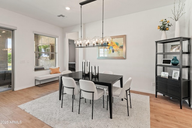 dining room featuring light wood finished floors, a chandelier, recessed lighting, baseboards, and visible vents