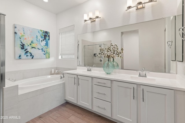 bathroom featuring a sink, double vanity, a shower stall, and a bath