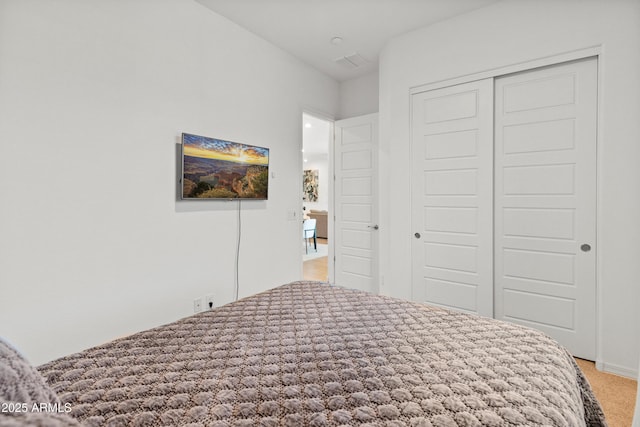 bedroom featuring light colored carpet and a closet