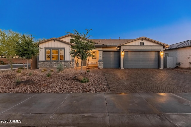 ranch-style home featuring a garage, board and batten siding, decorative driveway, and stone siding
