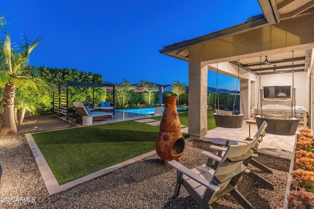 view of yard featuring a ceiling fan, outdoor lounge area, a patio area, and an outdoor pool