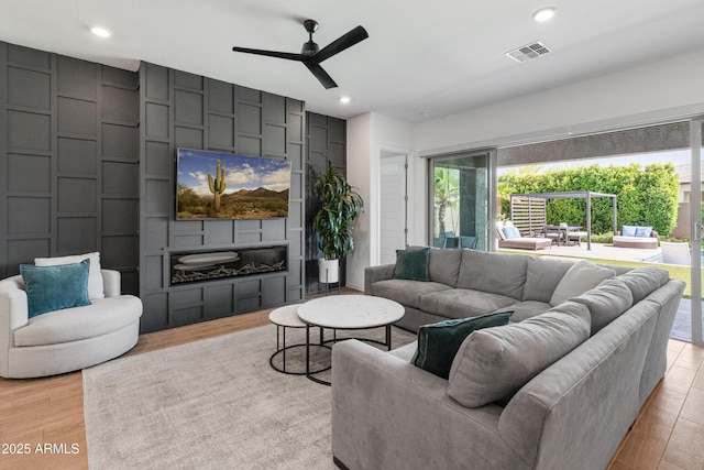 living area with a ceiling fan, visible vents, recessed lighting, and light wood-style floors