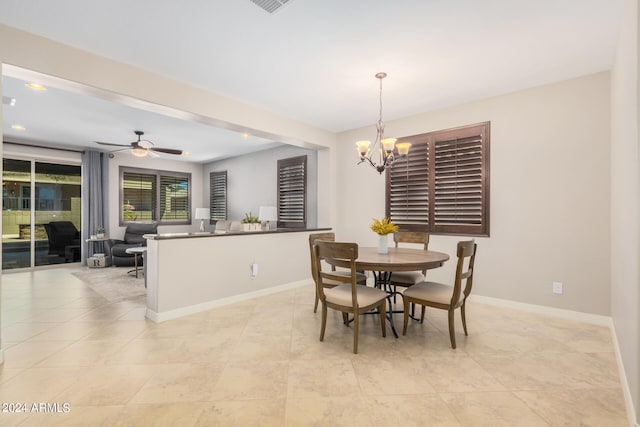 dining area featuring light tile patterned flooring and ceiling fan with notable chandelier