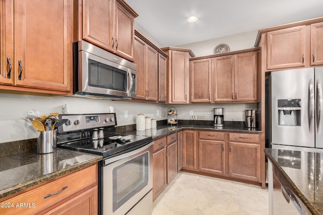 kitchen featuring appliances with stainless steel finishes and dark stone countertops