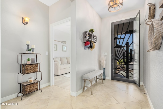 tiled foyer entrance featuring a notable chandelier