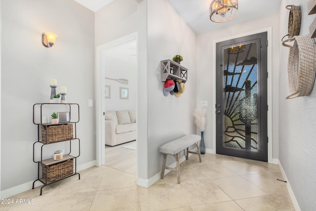 tiled foyer with a notable chandelier