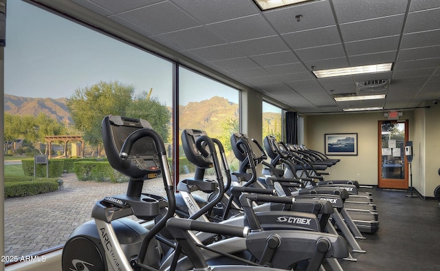 exercise room with a mountain view and a paneled ceiling