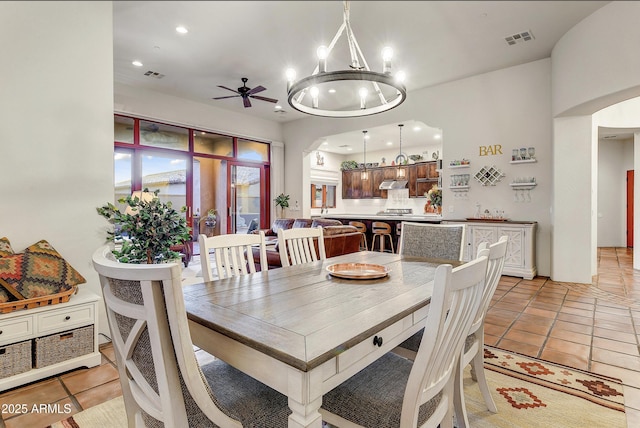 dining room featuring ceiling fan with notable chandelier and light tile patterned floors