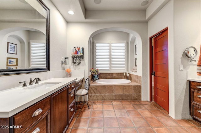 bathroom featuring tile patterned floors, vanity, and tiled tub