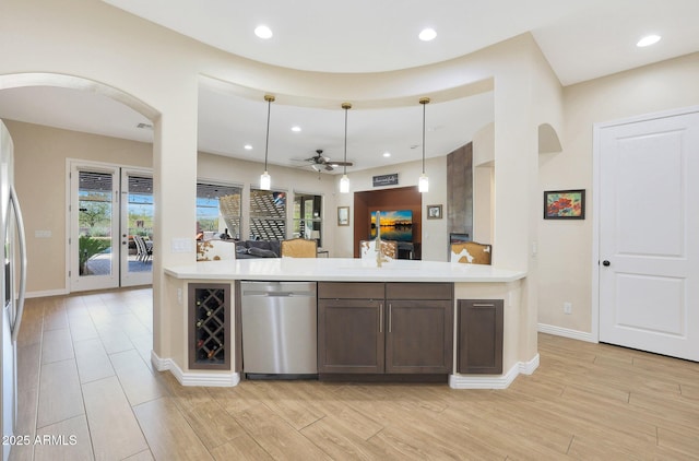 kitchen with dark brown cabinetry, ceiling fan, stainless steel appliances, wine cooler, and pendant lighting