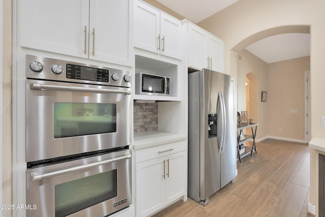 kitchen with white cabinets, backsplash, and stainless steel appliances