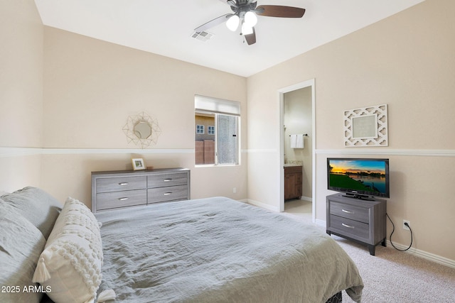 carpeted bedroom with ensuite bath and ceiling fan