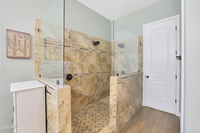 bathroom featuring hardwood / wood-style floors and a tile shower