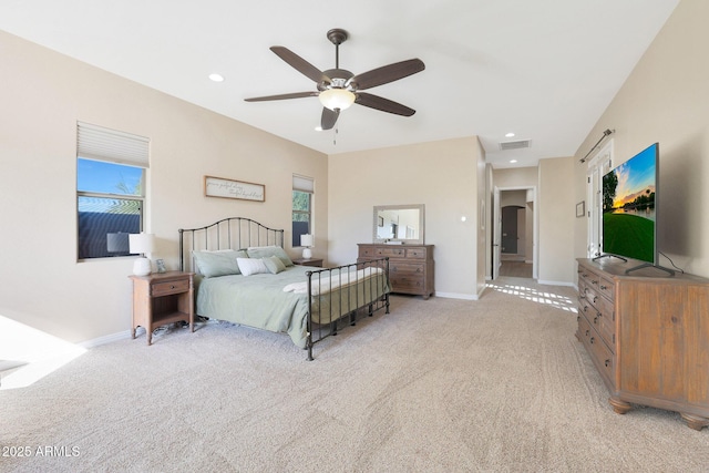 bedroom featuring multiple windows, ceiling fan, and light colored carpet