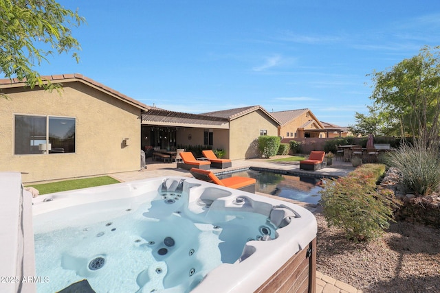 view of pool with a hot tub and a patio area