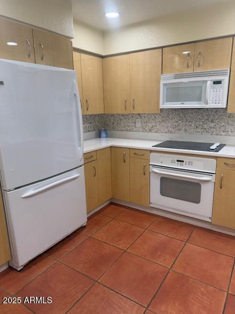 kitchen with tasteful backsplash, light tile patterned floors, white appliances, and light brown cabinets