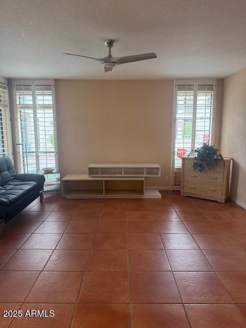 interior space with a wealth of natural light, tile patterned floors, and ceiling fan